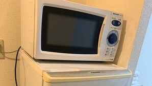 Un frigorifero compatto con un microonde integrato sopra.