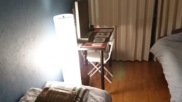 A hotel room with a bed, a desk, a chair, and a lamp. - Uzumasa 206 (Kyoto)