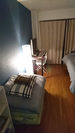 Una habitación de hotel con cama, escritorio, silla y lámpara.