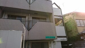 A multi-story building with a tiled facade and a sign indicating a business or service. - Uzumasa 206 (Kyoto)