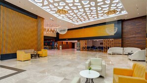 A spacious lobby with a high ceiling, modern chandeliers, and a mix of seating areas including sofas and armchairs. -  Grand Bellagio Batumi Convention & Casino Hotel (Batumi)