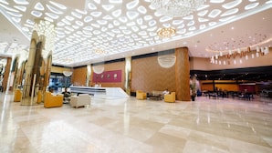 A spacious lobby with a high ceiling, modern chandeliers, and a reception desk. -  Grand Bellagio Batumi Convention & Casino Hotel (Batumi)