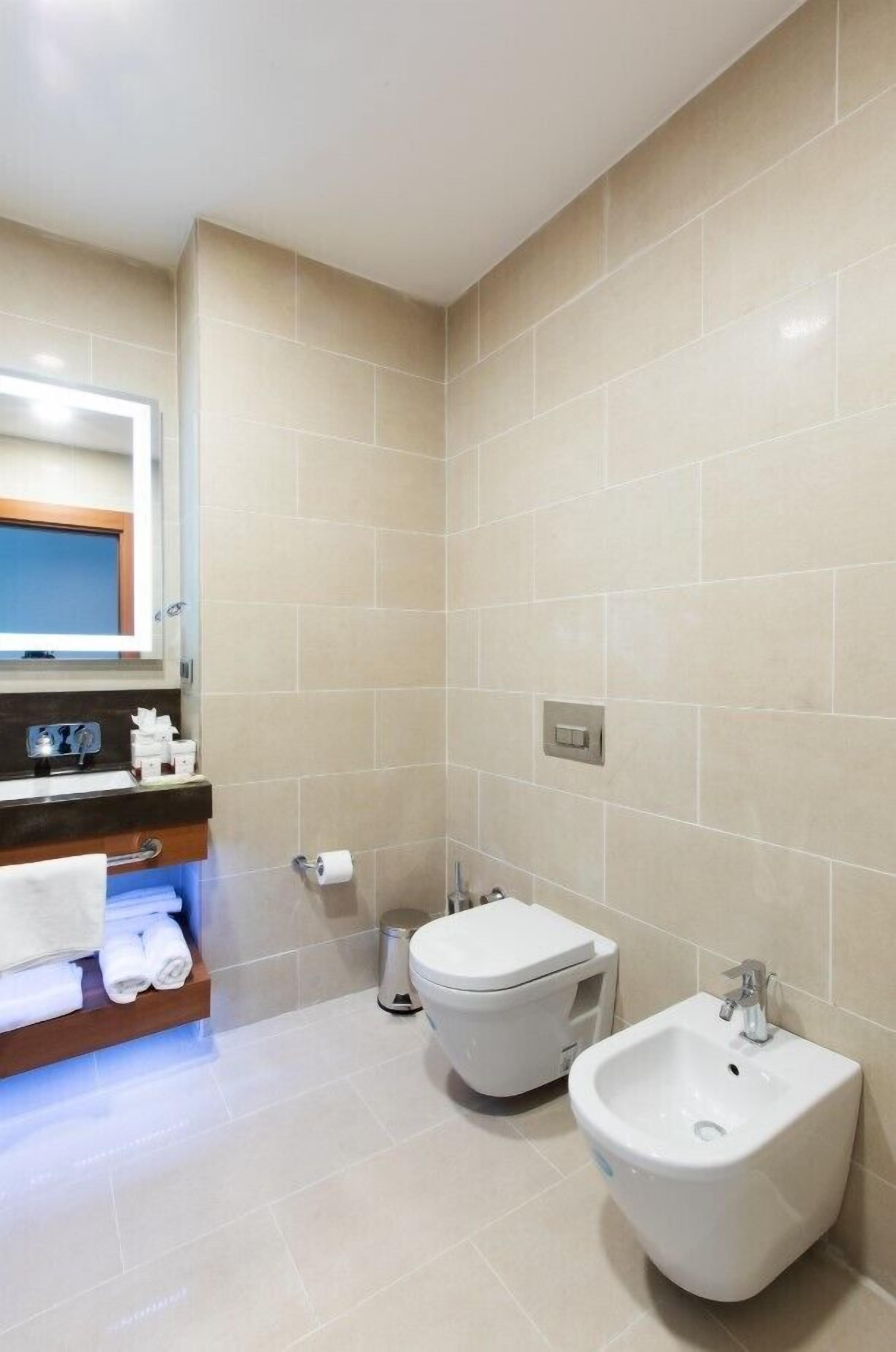 A modern bathroom with a toilet, bidet, and sink.