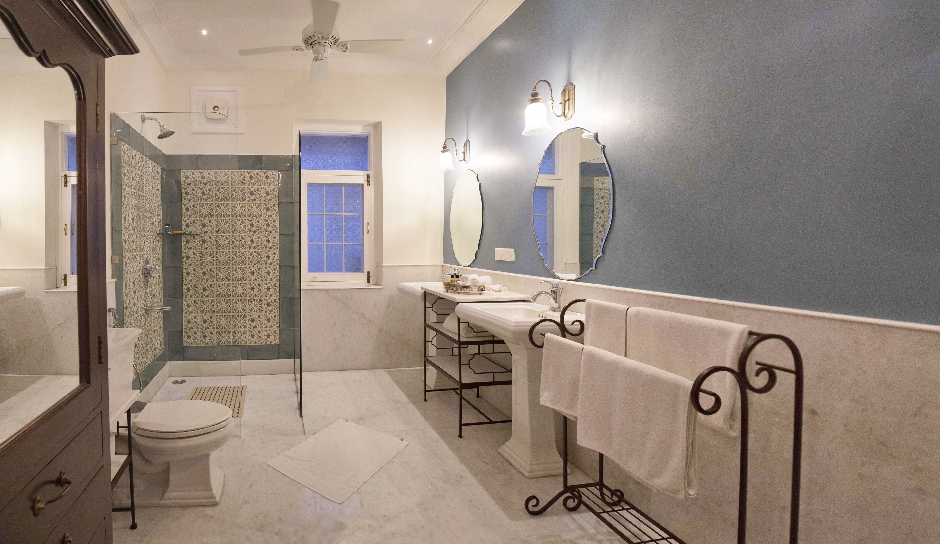 Un baño con ducha, inodoro, lavamanos y un espejo grande.