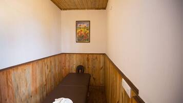 Cozy retreat with a single bed, wooden bench, and a floral wall art.