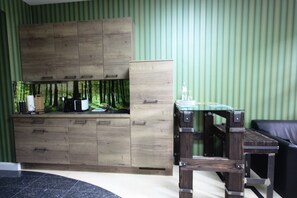 A room with a wooden cabinet, a glass table, and a black leather sofa. - Studio Forest - Romantic Apartments in Leipzig, *2km to the city center* (Leipzig)