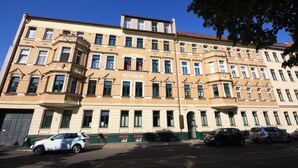 En bygning i flere etager med klassisk arkitektur, karakteriseret ved en markant indgang og flere vinduer.