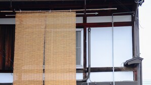 Un edificio tradizionale giapponese con tetto a tegole, cancello in legno e porta scorrevole di carta.