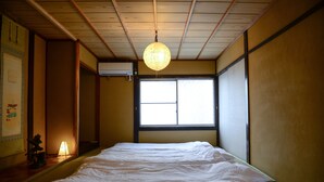 Una stanza con un letto, una finestra e un lampadario.