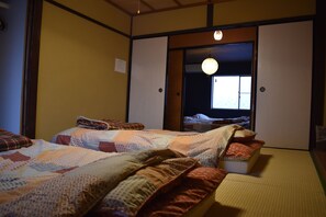 A traditional Japanese room with tatami flooring, two tatami mats, and a shoji screen door.