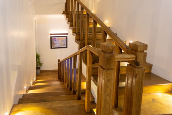 A wooden staircase with a handrail and a picture on the wall.
