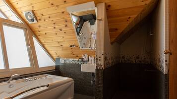 A bathroom with a bathtub, a sink, and a shower area.