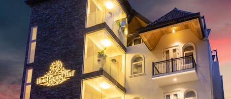 Ein mehrstöckiges Hotel mit einer auffälligen Schilder, auf denen "Hotel Grand Turf" steht.