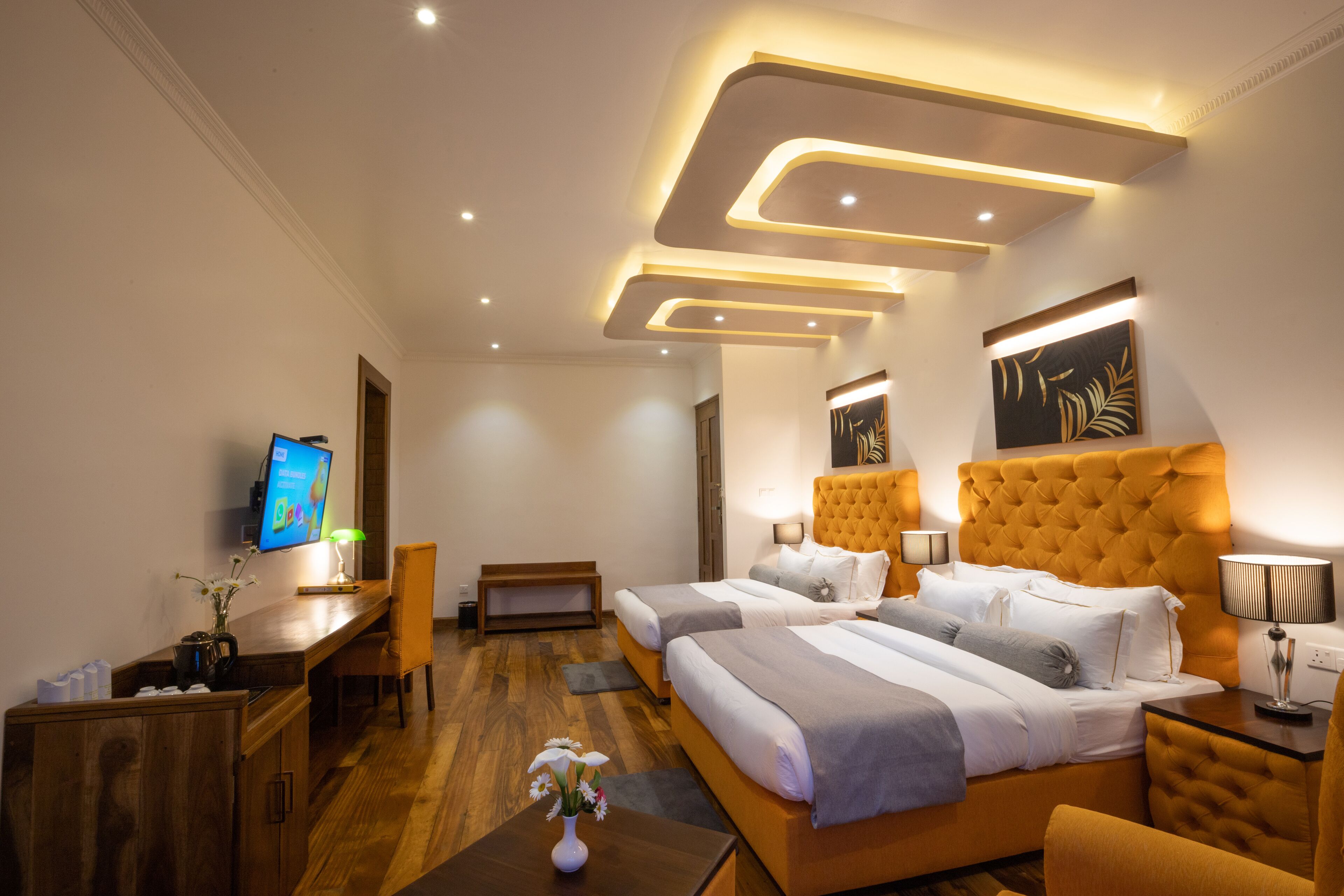 Una habitación de hotel moderna con una cama grande, un escritorio, un televisor y una zona de estar.