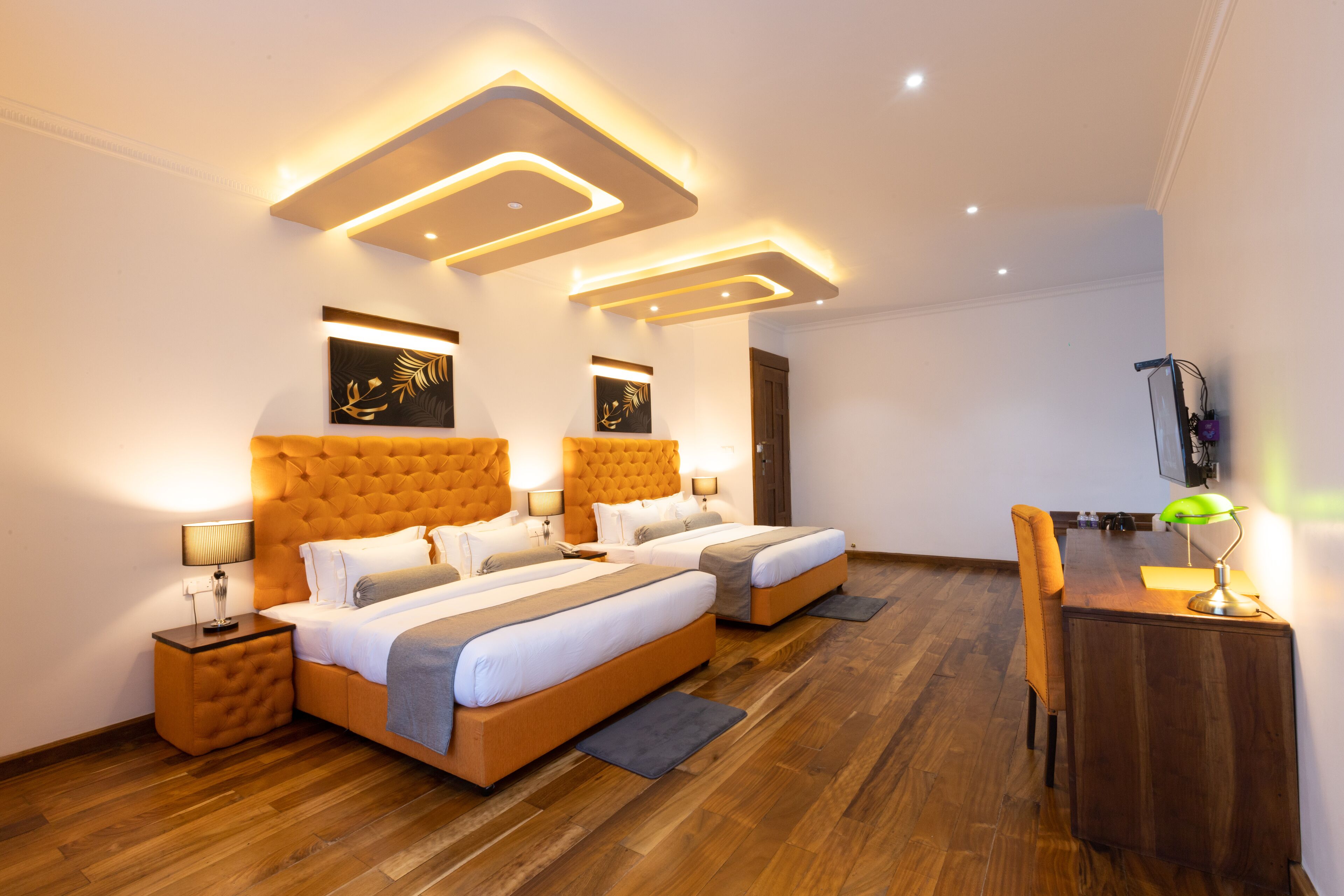 A modern hotel room with a large bed, a desk, and a chair.