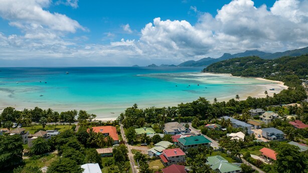 A coastal town with a beach, clear waters, and lush greenery. - 340 Mountain View Apartments (Mahé Island)