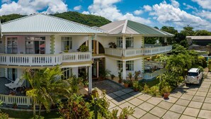 A two-story house with a balcony, a driveway, and a car parked outside. - 340 Mountain View Apartments (Mahé Island)