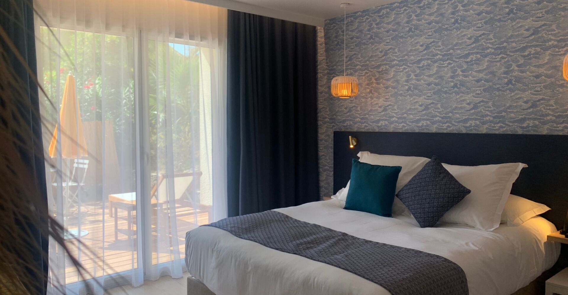 Una camera d'albergo con un letto, vista sull'esterno e una parete in pietra con decorazioni che ricordano le nuvole.