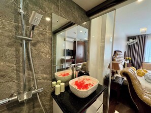 Luxe kamer | Badkamer | Een douche, een haardroger, pantoffels, handdoeken