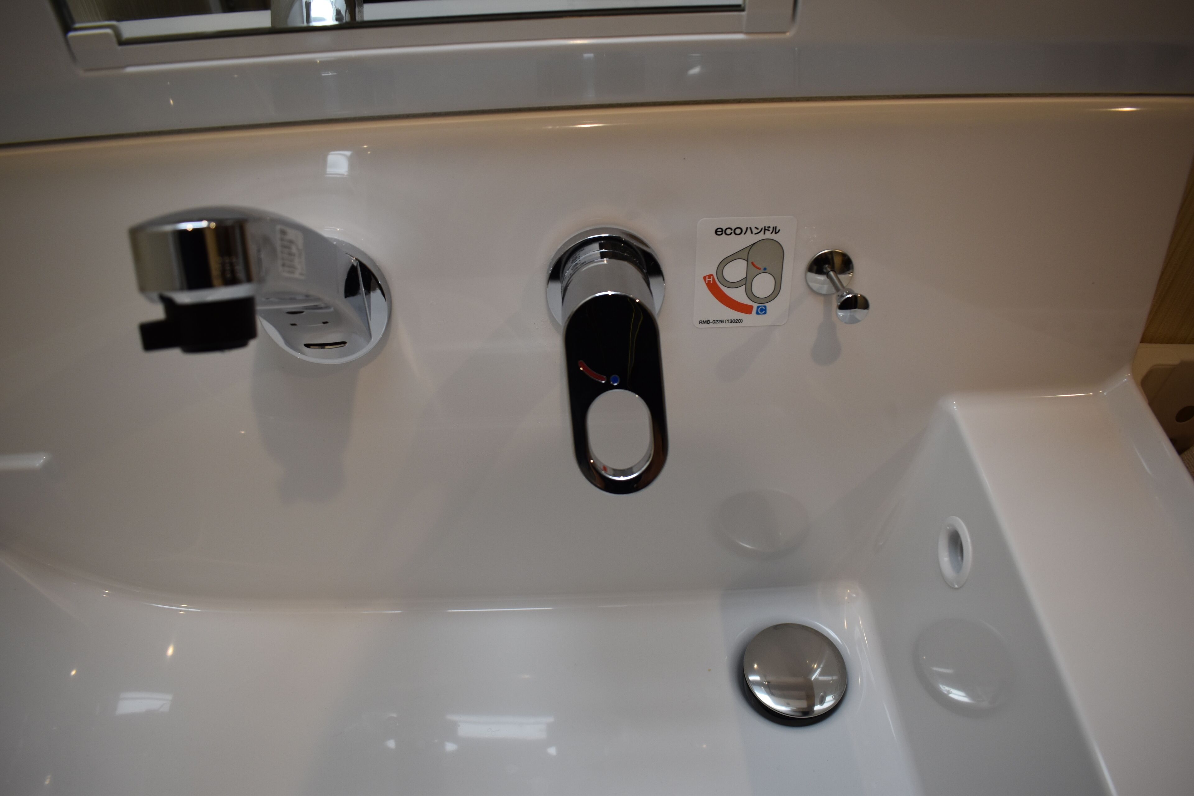 A white bathroom sink with a chrome faucet and a soap dispenser.