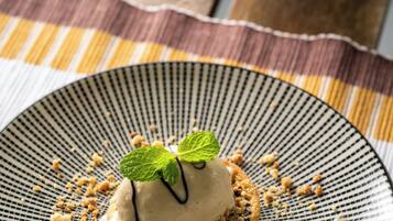 A dessert on a plate with a mint leaf garnish, placed on a table with a striped placemat.