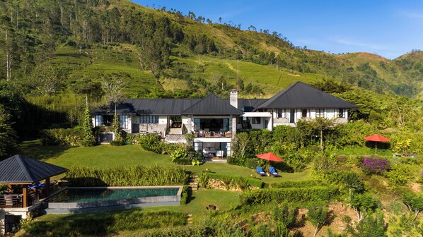 A large house with a pool, surrounded by lush greenery and hills. - Camellia Hills (Hatton)