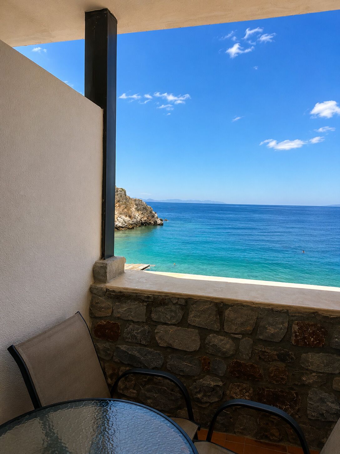 Un balcon offrant une vue dégagée sur la mer et un promontoire rocheux.