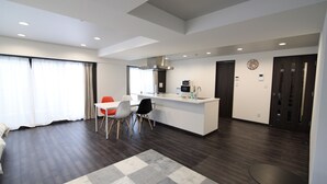 A modern hotel room with a dining area, a kitchen, and a large window with curtains. - Hotel Central Yokohama (Yokohama)