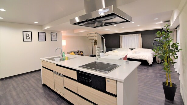 A modern kitchen with a built-in stove, dishwasher, and a large island. - Hotel Central Yokohama (Yokohama)
