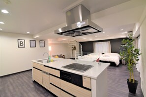 A modern kitchen with a built-in stove, dishwasher, and a large island. - Hotel Central Yokohama (Yokohama)