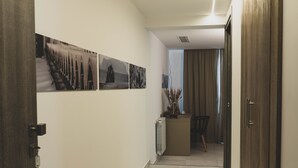A hallway with a radiator, a chair, and a table with a plant. - Hotel Pontemare (Palermo)