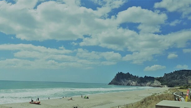 A beach with clear skies and waves.