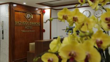 A reception desk with a wooden panel and a sign reading "BAO NGOC DIAMOND HOTEL".