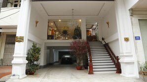 L’entrée de l’hôtel Bảo Ngọc Diamond se distingue par un grand escalier, des plantes en pot et un lustre.