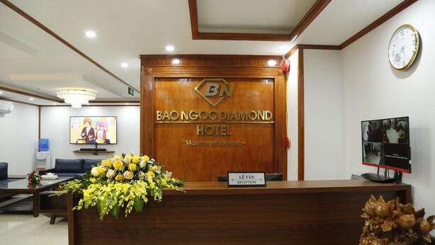 Un comptoir d'accueil à l'hôtel Bao Ngoi Diamond, avec une pancarte indiquant la zone de réception.