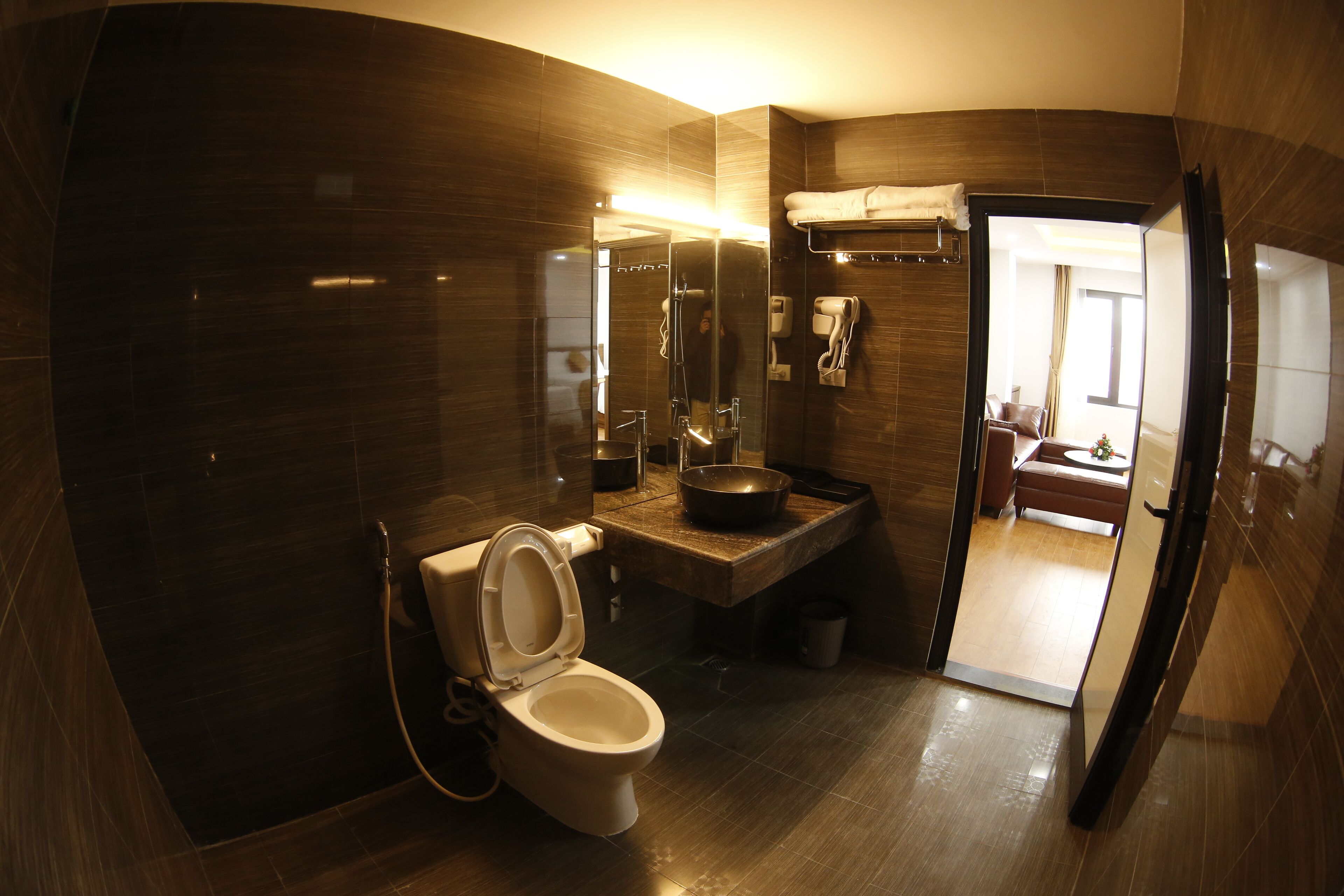 A modern bathroom with a toilet, sink, and mirror.