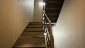 Eine Treppe mit Metallgeländer, die zu einer Zwischenebene führt.