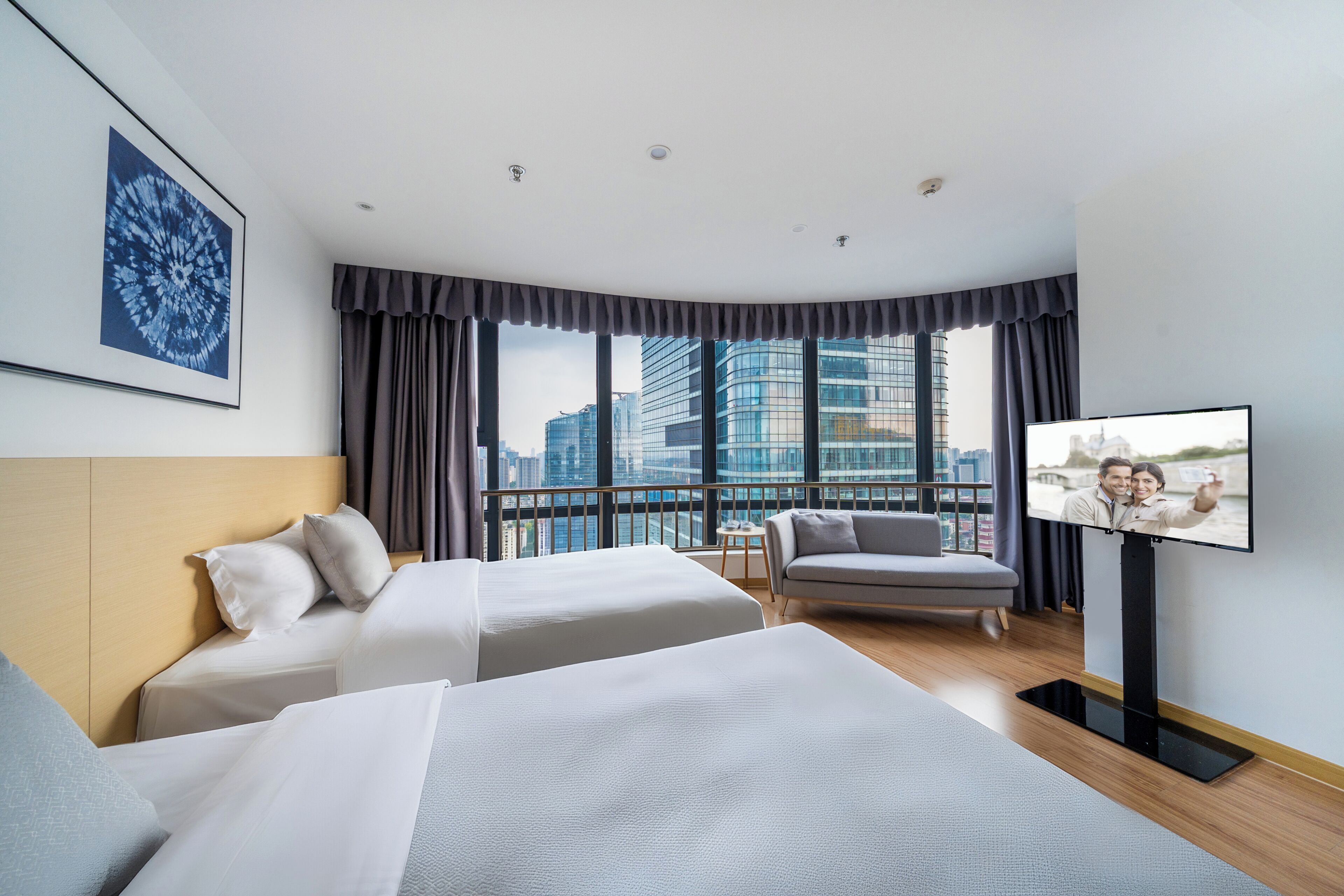 Une chambre d’hôtel avec deux lits, une télévision, une vue sur la ville et un design moderne.