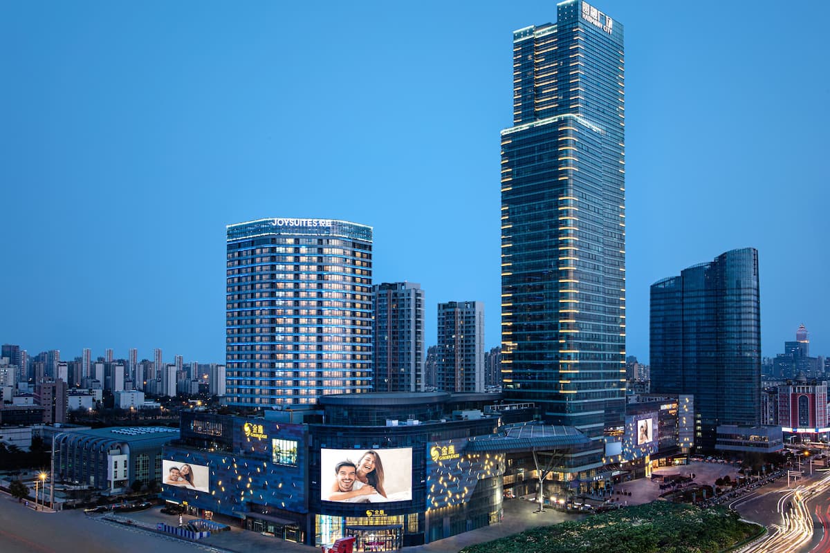 Un hôtel de grande hauteur au design moderne, caractérisé par une façade incurvée imposante et une enseigne lumineuse.