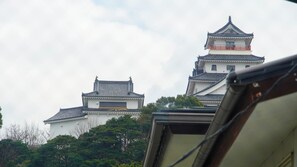 A traditional Japanese castle with multiple tiers and a prominent red railing on the upper levels. - Ryokan Oomasa (Karatsu)