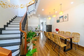 A modern interior with a staircase, dining area, and kitchen. - Kivi Homestay (Da Nang)