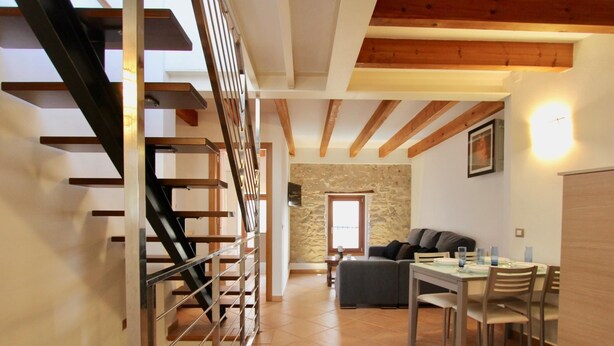 Un vaste espace de vie comprenant un escalier, une table à manger et un canapé.