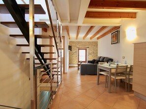 A spacious living area with a staircase, a dining table, and a sofa. - Eu Forat: Townhouse centrally located in Pollensa (Pollença)