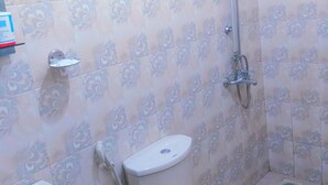 A bathroom with a toilet, bidet, and shower. - 59B Rest Inn Ella (Ella)