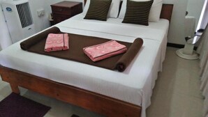 A neatly made bed with a brown bedspread and two pink towels. - 59B Rest Inn Ella (Ella)