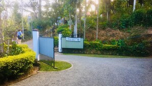A gravel pathway leading to a gated entrance with a sign for '59B REST INN'. - 59B Rest Inn Ella (Ella)