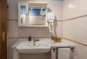A bathroom with a white sink, a mirror with a window, a toilet, and a towel rack. - La Scaletta Della Rocca (Castellina in Chianti)