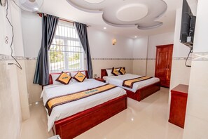 A hotel room with two beds, a ceiling fan, a TV, and a window with curtains. - Hotel Huong Dao (Ho Chi Minh City)