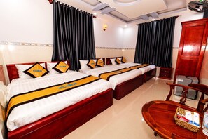A hotel room with two beds, a wooden wardrobe, a desk with a chair, and a small table with a basket. - Hotel Huong Dao (Ho Chi Minh City)