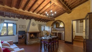 Un intérieur rustique avec une cheminée, un coin repas et une cuisine.